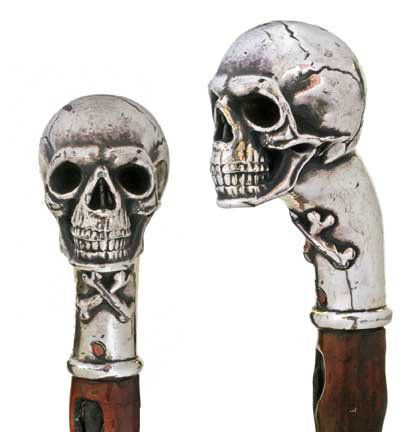 Skull and Bone Silver Dress-First half of 20th Cen: Skull and Bone Silver Dress-First half of 20th Century-A signed sterling handle which contains a rattle, exotic wood shaft and an old brass ferrule-H. 3 ½" x 2 ½", O.L. 36"-$700-$1,200