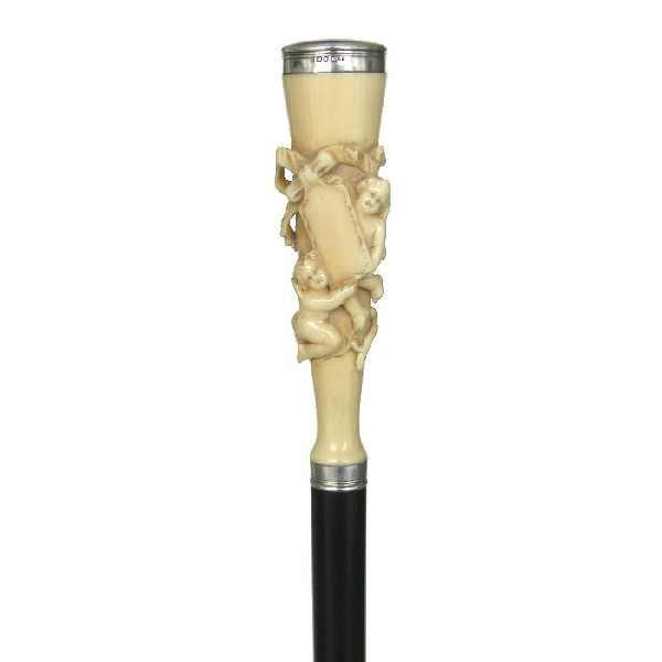 Ivory Cherub Cane-Hallmarked 1897-A large 5 ½" ivor: Ivory Cherub Cane-Hallmarked 1897-A large 5 ½" ivory handle carved in high relief, ebony shaft, silver collar, round cap with Sheffield hallmarks and a maker's mark of A&D. and a stag horn ferrule-O.