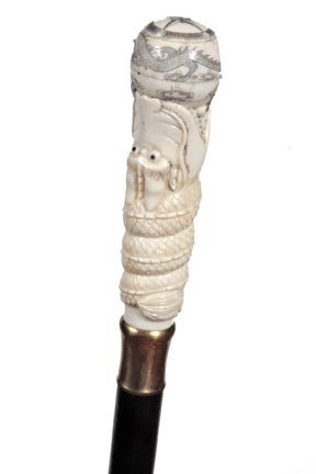 Bone Dress Cane-Circa 1970-Carved bone handle whic: Bone Dress Cane-Circa 1970-Carved bone handle which has a modern compass, brass collar, ebonized shaft and a brass ferrule-H. 5 ¼" x 1 ½", O.L. 36"-$200-$250