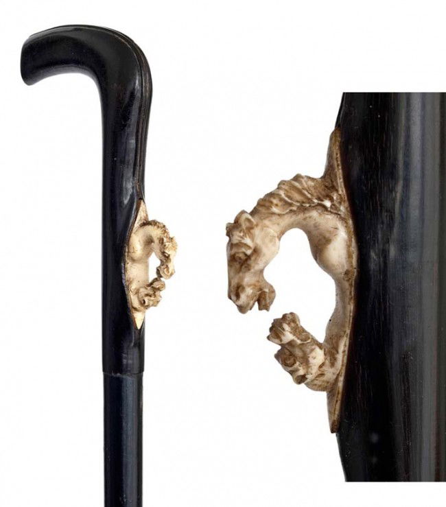 Fancy Dress Cane -19th Century, possibly French-L-s: Fancy Dress Cane -19th Century, possibly French-L-shaped black horn handle with a well carved ivory medallion showing a horse head facing a dog head, ebony shaft with a horn ferrule-H. 4 ¼" x 3", O.L