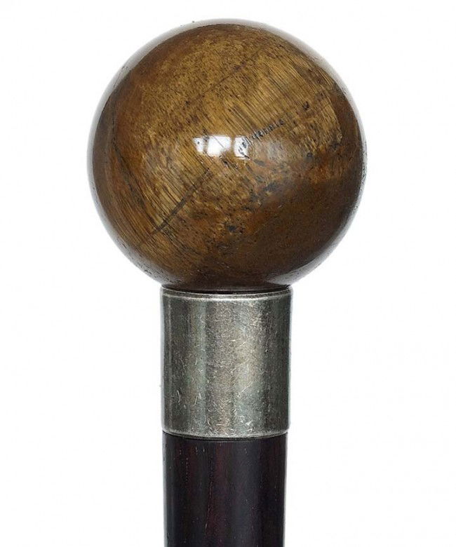 Tiger Eye Knob Dress Cane-Late 19th Century-The ba: Tiger Eye Knob Dress Cane-Late 19th Century-The ball handle with a brown-gold petrified wood structure, rosewood shaft, white metal collar and a horn ferrule-H. 1 3/4" diameter, O.L. 38" $400-$700