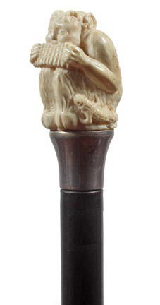 Ivory Pan Dress Cane-Circa 1880-A whimsical carvin: Ivory Pan Dress Cane-Circa 1880-A whimsical carving which has a lizard and mice listening to the music, fluted silver collar, ebonized shaft and no ferrule-H. 1 ½" x 2 ¼", O.L. 36"-$1,000-$1,500
