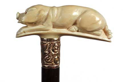 Ivory Pig Cane-Early 20th Century-Carved Ivory Pig: Ivory Pig Cane-Early 20th Century-Carved Ivory Pig with coral eyes, ornate gold filled collar, mahogany shaft and a bi-metal ferrule-H. 4 ½" x 1 ¾", O.L. 34"-$800-$1,000