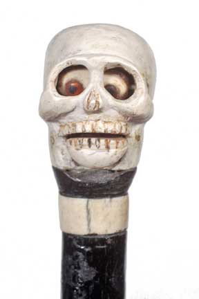 Skull Cane-Circa 1940-An unusual composition and w: Skull Cane-Circa 1940-An unusual composition and wood Halloween cane, automated eyes and mouth which is slowly working, bone collar, ebonized shaft and a brass ferrule-H. 1 ¾” x 1 ¾”, O.L. 35”