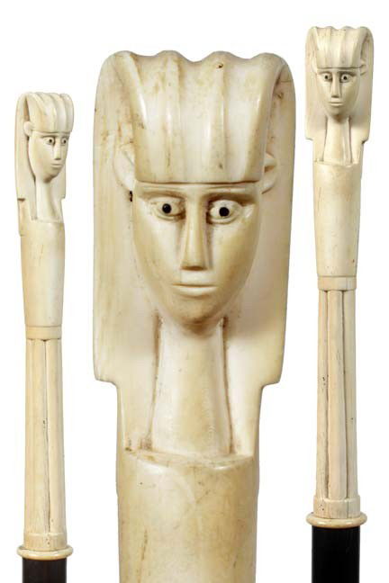 Antique cane Egyptian Revival: 27. An Egyptian Revival 9" x 1 ¼" early 20th Century ivory handle, ivory spacer, ebony shaft, 36" O.L. , 2" ivory ferrule-$500-$700