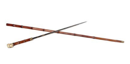 111. Ivory Sword Cane-Circa 1880-Carved ivory pira: 111. Ivory Sword Cane-Circa 1880-Carved ivory pirates head with two color glass eyes, brass collar, a 15" blued and gold etched blade, brass collar, bamboo shaft and a brass ferrule-H. 1 ¼" x 1 ½", 