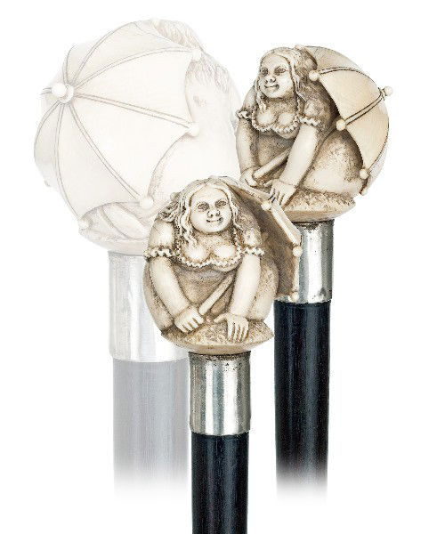 130. Ivory Girl with Umbrella Cane-Last quarter of: 130. Ivory Girl with Umbrella Cane-Last quarter of the 19th Century-Ivory ball knob carved with a girl kneeling under an umbrella, ebony shaft with plain silver collar and brass ferrule-H. 2 ¼" x 2 �