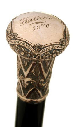 32. Gold Dress Cane-Dated 1870-An ornate gold fille: 32. Gold Dress Cane-Dated 1870-An ornate gold filled 1 ¼" x 1 ¾" presentation cane, "Father 1870", ebony shaft and a horn ferrule-O.L. 35"-$300-$500