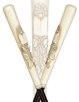 Feminine Ivory Dress Cane-French, 19th Century-Tok: Feminine Ivory Dress Cane-French, 19th Century-Token­Of-Love ivory handle carved with a shell, a book and two roses, slender ebony shaft with a brass ferrule.-H. 5 ½" x ¾", O.L. 36 ½" $400-$600