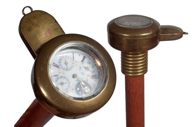 96. Coal Miners Watch Cane- Late 19th Century.- A b: 96. Coal Miners Watch Cane- Late 19th Century.- A brass watch holder which contains a steel watch, these holders were used to protect watches for miners in the district of Wales, brass collar, hardwoo