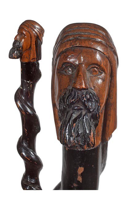 129. Biblical Scholar Cane-Late 19th Century-A car: 129. Biblical Scholar Cane-Late 19th Century-A carved and painted folk- art cane with natural vine growth with a devil head carved near the center and a metal ferrule. H. 2 ½" x 2", O.L. 34", $250-$4