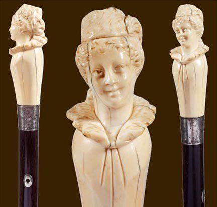189. Victorian Dress Cane-Late 19th Century-A large car: 189. Victorian Dress Cane-Late 19th Century-A large carved ivory lady, hallmarked ornate silver collar, silver eyelets, exotic wood shaft and a bi-metal ferrule-H. 4 ¼" x 1 ½", O.L. 36"-