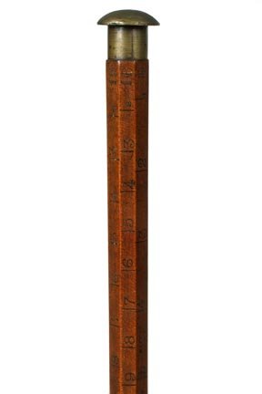 106. Measuring Stick Cane-Late 19th Century-Kerby and D: 106. Measuring Stick Cane-Late 19th Century-Kerby and Davidson NY measuring device, small metal top, marked for measuring lumber, hexagonal hardwood shaft and a brass ferrule. H. 1 ¼" x 1", O.L. 36"