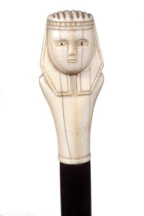 175. Egyptian Ivory Cane-Ca. 1925-A nicely carved figur: 175. Egyptian Ivory Cane-Ca. 1925-A nicely carved figure with painted eyes, small ivory collar, ebony shaft and a horn ferrule-H. 3” x 1 ¼”, O.L. 36”-