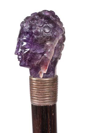 231. Asian Amethyst Cane-Ca. 1930-A carved amethyst, ri: 231. Asian Amethyst Cane-Ca. 1930-A carved amethyst, ribbed white metal collar, ebony shaft and a metal ferrule-H. 1 ½” x 2”, O.L. 35”-