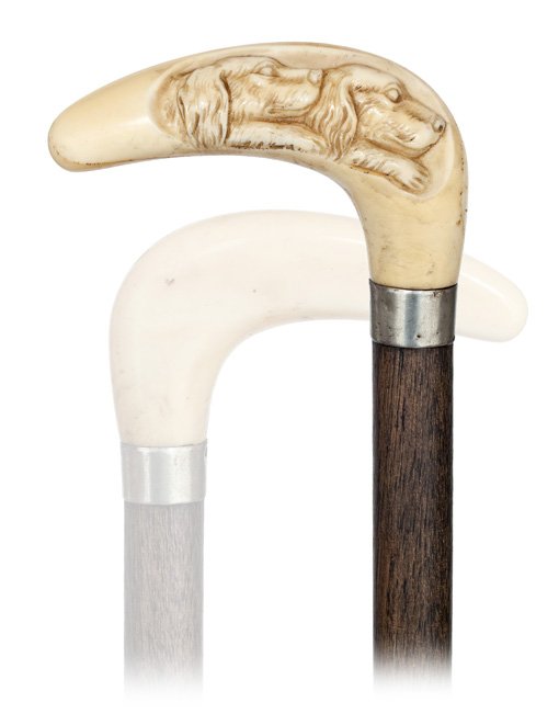 109. Ivory Dogs Cane-Ca. 1890-L-Shaped hippopotamu: 109. Ivory Dogs Cane-Ca. 1890-L-Shaped hippopotamus ivory handle with rounded edges carved with two dog heads, fruitwood shaft with a white metal collar and a brass ferrule.-H. 3 x 2, O.L. 35 -