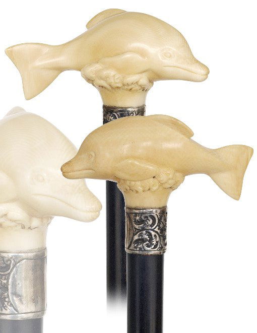 17. Ivory Dolphin Cane-Ca. 1890-The ivory handle is car: 17. Ivory Dolphin Cane-Ca. 1890-The ivory handle is carved of a single piece of select material to depict a dolphin riding on waves. Ebony shaft with a horn ferrule and with a chased silver collar str