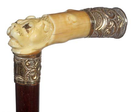84. Ivory Bull Dog Cane-Ca. 1900-A carved ivory handle : 84. Ivory Bull Dog Cane-Ca. 1900-A carved ivory handle of a bull dog with two colored glass eyes, ornate gold filled end cap, matching gold filled collar, exotic wood shaft and a metal ferrule. H. 4 �