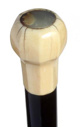 169. Going Ashore Cane-Ca. 1850-A carved ivory handle w: 169. Going Ashore Cane-Ca. 1850-A carved ivory handle with a 1” mother of pearl disc atop, well carved a patinated thick ebony shaft and a metal ferrule-H. 2 ½” x 1 ½”, O.L. 36”