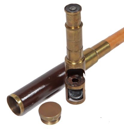 119. Microscope System Cane-Ca. 1940-A brass and leathe: 119. Microscope System Cane-Ca. 1940-A brass and leather department cane which holds a 3 draw mirrored 7” microscope in working condition, leather handle, large brass collar, malacca shaft and a hor