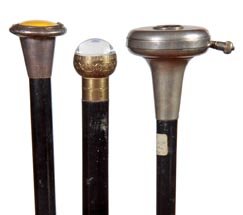 235. Lot of Three System Canes-A modern watch cane made: 235. Lot of Three System Canes-A modern watch cane made to look old, a 1920’s battery operated torch, enamel and silver compartment cane with mirror with minor damage to rim-