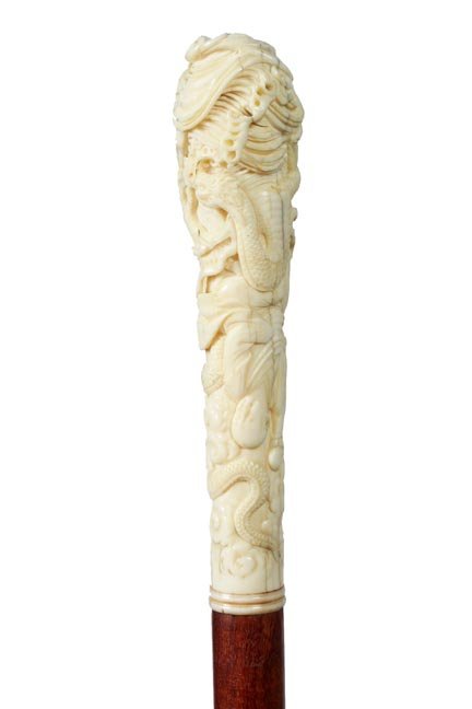 51. Chinese Ivory Dragon Cane-Ca. 1900-A fancy carved h: 51. Chinese Ivory Dragon Cane-Ca. 1900-A fancy carved handle with a large dragon and various people, exotic wood shaft and a horn ferrule-H. 5” x 1 ¼”, O.L. 36”-