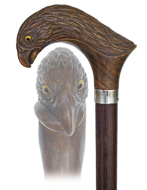 120. Figural Day Cane-Ca. 1900-Large and curving Lignum: 120. Figural Day Cane-Ca. 1900-Large and curving Lignum Vitae handle carved to depict a predatory bird’s head with a snake in its mighty beak, well figured feather coat and inset glass eyes, rosewoo