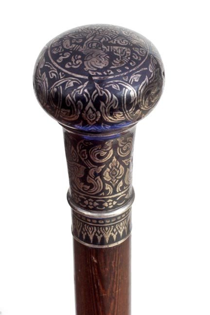 186. Silver and Enamel Dress Cane-Late 19th Century-An : 186. Silver and Enamel Dress Cane-Late 19th Century-An East Asian/British Colonial cane, demon heads on sides and top, mahogany shaft and a metal ferrule-H. 2 ¾” x 1 ½”, O.L. 31 ¼”-