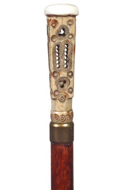 50. Bone Rattle Cane-Ca. 1900-A unique carved bone: 50. Bone Rattle Cane-Ca. 1900-A unique carved bone handle with one rattle ball within, ivory disc atop, brass collar, hardwood shaft and a metal ferrule-H. 1 ¼” x 3 ¾”, O.L. 34”