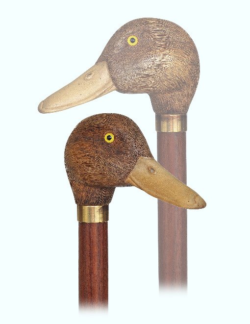 133. Duck Head Day Cane-Ca. 1920-A well carved and: 133. Duck Head Day Cane-Ca. 1920-A well carved and naturalistically colored boxwood duck head with inset glass eyes, pear wood shaft, gilt metal collar and a metal ferrule.-H. 4 ¼” x 2 ½”, O.L. 