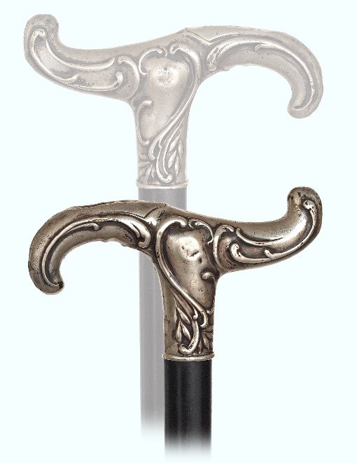 149. Silver Dress Cane-Ca. 1890-Silver Derby handle: 149. Silver Dress Cane-Ca. 1890-Silver Derby handle hand chased and engraved with Baroque scrolls, ebony shaft and a horn ferrule. German hallmarks.-H. 4 ¾” x 3”, O.L. 37”-