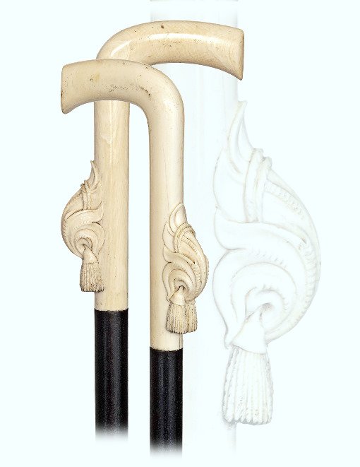 168. Ivory Dress Cane-19th Century-L-shaped ivory: 168. Ivory Dress Cane-19th Century-L-shaped ivory handle ornate with an integral pair of tassels hanging against a shell, ebony shaft and a horn ferrule. German.-H.4 ¾” x 3 ¼”, O.L. 33 ¾”-