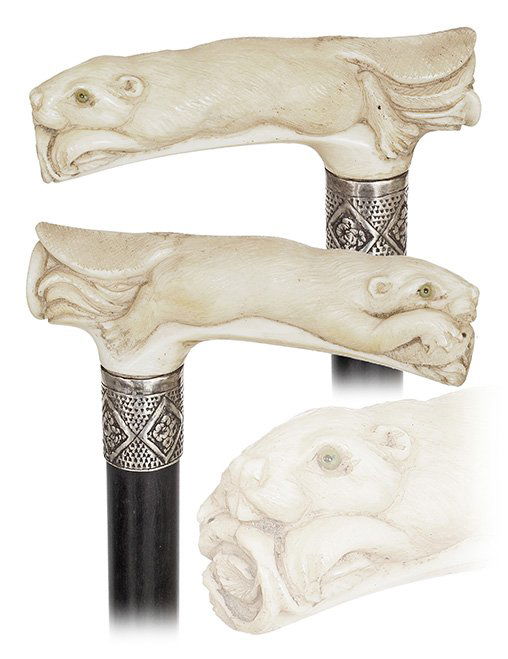 17. Ivory Figural Day Cane-Ca. 1890-Ivory Opera shaped: 17. Ivory Figural Day Cane-Ca. 1890-Ivory Opera shaped handle carved with an otter like webbed foot mammal showing a slim body with a thick and smooth fur, ebony shaft with a well chased silver collar