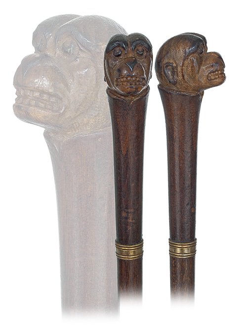127. Folk Art Cane-Ca. 1900-Straight hardwood handle: 127. Folk Art Cane-Ca. 1900-Straight hardwood handle topped by a carved monkey’s head with dark stain highlights, hardwood shaft with a brass collar and a horn ferrule.-H. 5 ¼” x 1 ¾”, O.L. 37