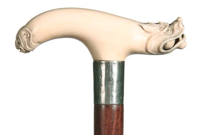 140. Ivory Dragon Cane-Ca. 1885-A carved ivory dragon: 140. Ivory Dragon Cane-Ca. 1885-A carved ivory dragon handle with a loose ball in its mouth, another creature carved on the back end of the handle, coin silver unreadable hallmarked British collar, ex