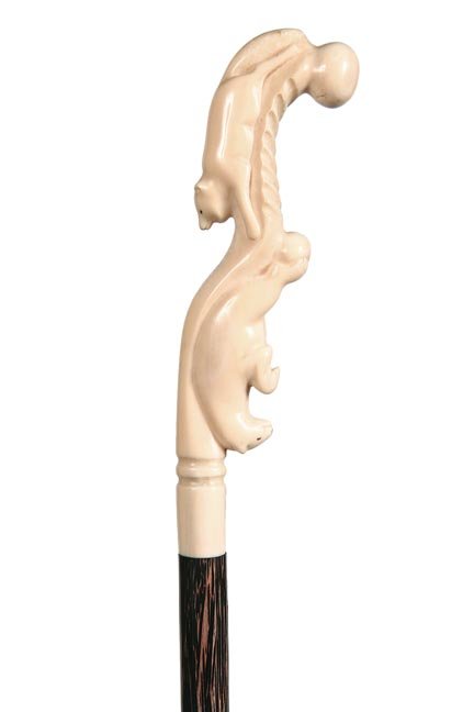 150. Inuit Walrus Cane-Ca. 1925-A nice stylized carving: 150. Inuit Walrus Cane-Ca. 1925-A nice stylized carving of a fox and bear in walrus ivory, baleen inset eyes, exotic wood shaft and an ivory ferrule-H. 2” x 7 ½”, O.L. 36”-