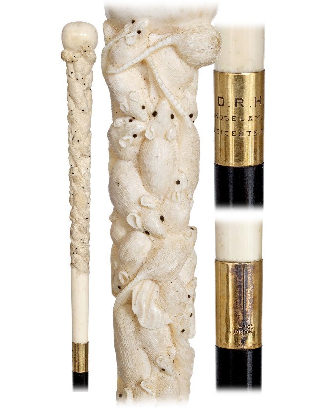 39. Ivory Brigg Day Cane-Ca. 1880-Long and straight: 39. Ivory Brigg Day Cane-Ca. 1880-Long and straight ivory handle carved with a multitude of rats, ebony shaft with a 3 ¾” tall stag horn ferrule and a gilt collar engraved “D.R.H. NASELLY. LEICES