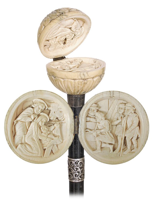 63. Ivory Nativity Cane-Ca. 1870- Ivory ball knob: 63. Ivory Nativity Cane-Ca. 1870- Ivory ball knob carved with a radiating daisy pattern, ebony shaft with a finely chased silver collar with tiny English hallmarks and a brass ferrule. The hinged ball