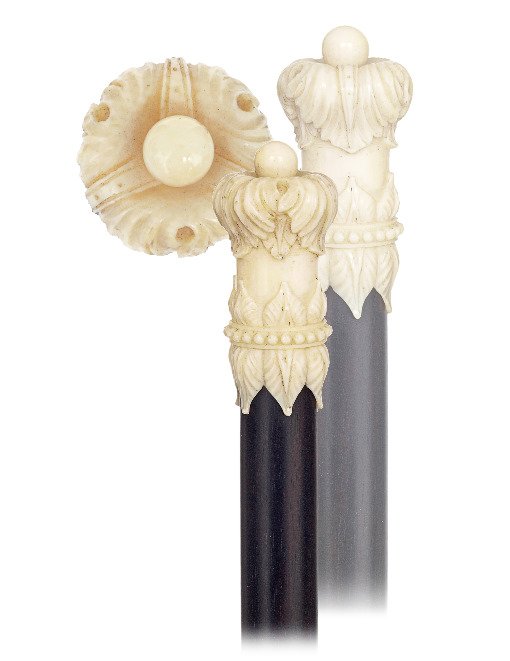 48. Ivory and Ebony Dress Cane -Ca. 1870-Ivory knob: 48. Ivory and Ebony Dress Cane -Ca. 1870-Ivory knob delicately carved with a crown over an integral collar with stylized leaves centered by a ring of dots, ebony shaft and an ivory ferrule. Top rate F