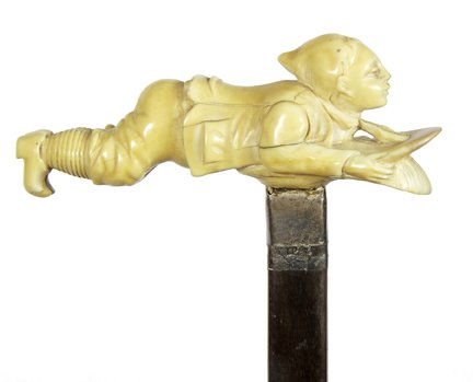 130. Ivory Snow Sledding Cane-Ca. 1880-A complicated: 130. Ivory Snow Sledding Cane-Ca. 1880-A complicated ivory handle of a young man sledding, a very detailed work, silver collar, exotic wood shaft and a metal ferrule-H. 4 ¼” x 1 ¾”, O.L. 34 ½��