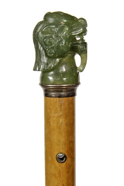86. Chinese Jade Dragon Cane- Late 19th Century-A: 86. Chinese Jade Dragon Cane- Late 19th Century-A carved dragon which appears to be jade, coin silver pedestal collar, silver eyelets, honey malacca shaft and a horn ferrule- H. 1 ¾” x 2 ¼”, 