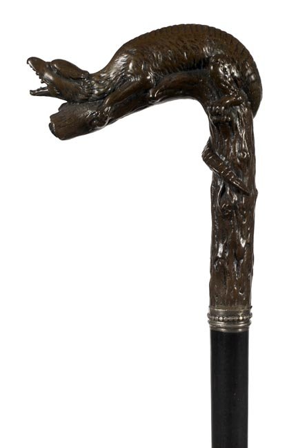 15. Burl Carved Dress Cane- Ca. 1900-A fierce carved: 15. Burl Carved Dress Cane- Ca. 1900-A fierce carved creature possibly a dragon,which is carved in a one-piece handle, raised sterling collar, ebony shaft and an ivory ferrule. H. 4 ¼” x 5 ¼��