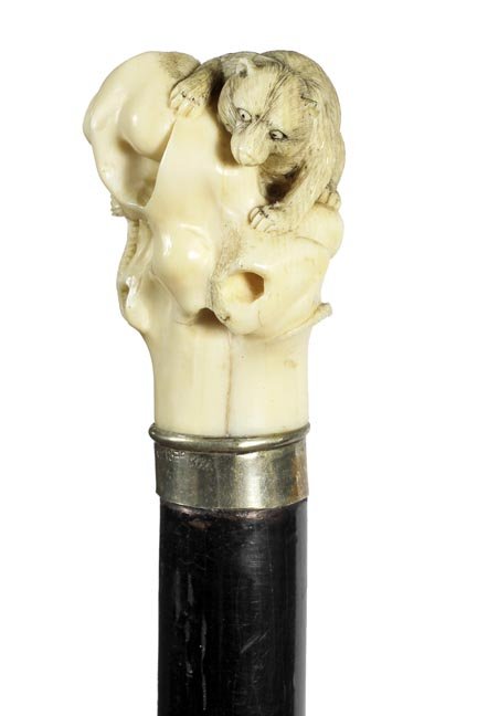 53. Japanese Mongoose/Cobra Ivory Cane- Ca.: 53. Japanese Mongoose and cobra Ivory Cane- Ca. 1890-A fully carved handle with a raccoon being attacked by a snake, silver metal collar, ebony shaft and a horn ferrule. H. 1 ¾” x 2 ¼”, O.L.