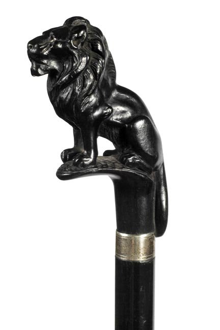 105. Carved Lion Cane- An ebony carved lion standing on: 105. Carved Lion Cane- An ebony carved lion standing on a branch, signed sterling collar, ebony shaft and a metal ferrule. H. 3” x 4”, O.L.-38”