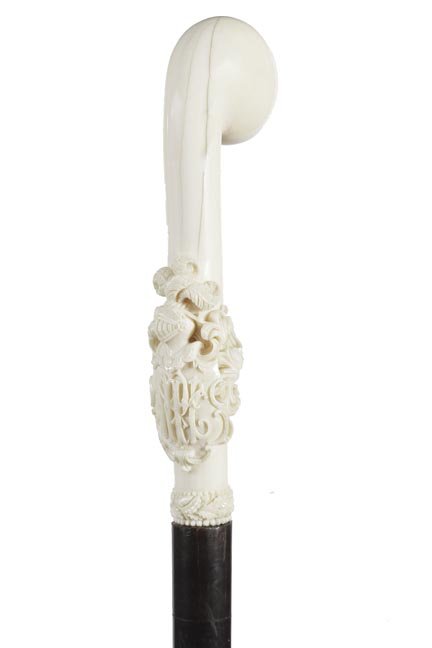 136. Ivory Dress Cane- Ca. 1875-A nicely carved ivory: 136. Ivory Dress Cane- Ca. 1875-A nicely carved ivory dress cane with an amour crest and flumed helmet, ornate carved ivory collar, ebony shaft and a metal ferrule. H. 2” x 6 ½”, O.L.-40 �