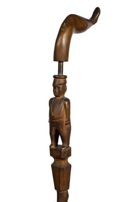 172. Folk-Art Man - Ca. 1915- Carved folk-art man in: 172. Folk-Art Man - Ca. 1915- Carved folk-art man in hat with is hands in pocket, could be a miner, exposed metal above hat, great large naughty leg handle, fully carved front and back, American waln