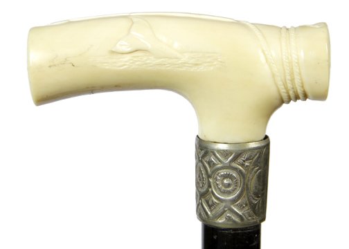 142. Ivory Whale Cane- Pre-Ban-A carved walrus tusk,: 142. Ivory Whale Cane- Pre-Ban-A carved walrus tusk, ivory handle with a whale’s front on one side and his tail sticking out on the other side, nautical rope for a thumb rest and a carved harpoon a