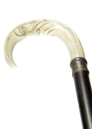 188. “Man in the Moon” Ivory Cane- Ca. 1910-A carved: 188. “Man in the Moon” Ivory Cane- -A carved ivory handle with the face inscribed on the underside, silver metal collar, ebony shaft and no ferrule-H. 4” x 3”, O.L. 33”
