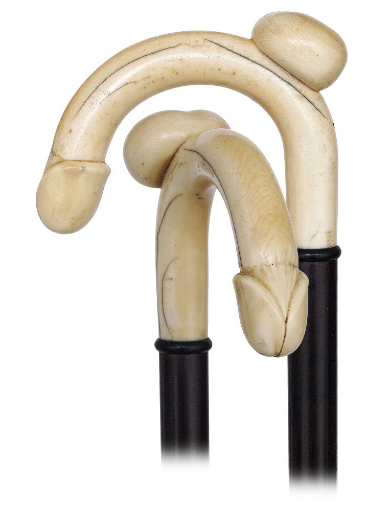 12. Ivory Erotic Dress Cane-Ca. 1900-Ivory crook handle: 12. Ivory Erotic Dress Cane-Ca. 1900-Ivory crook handle depicting the intimate organs of a man, ebony shaft and a stag horn ferrule.-H. 4 ¾” x 3 ½”, O.L. 36 ¾”