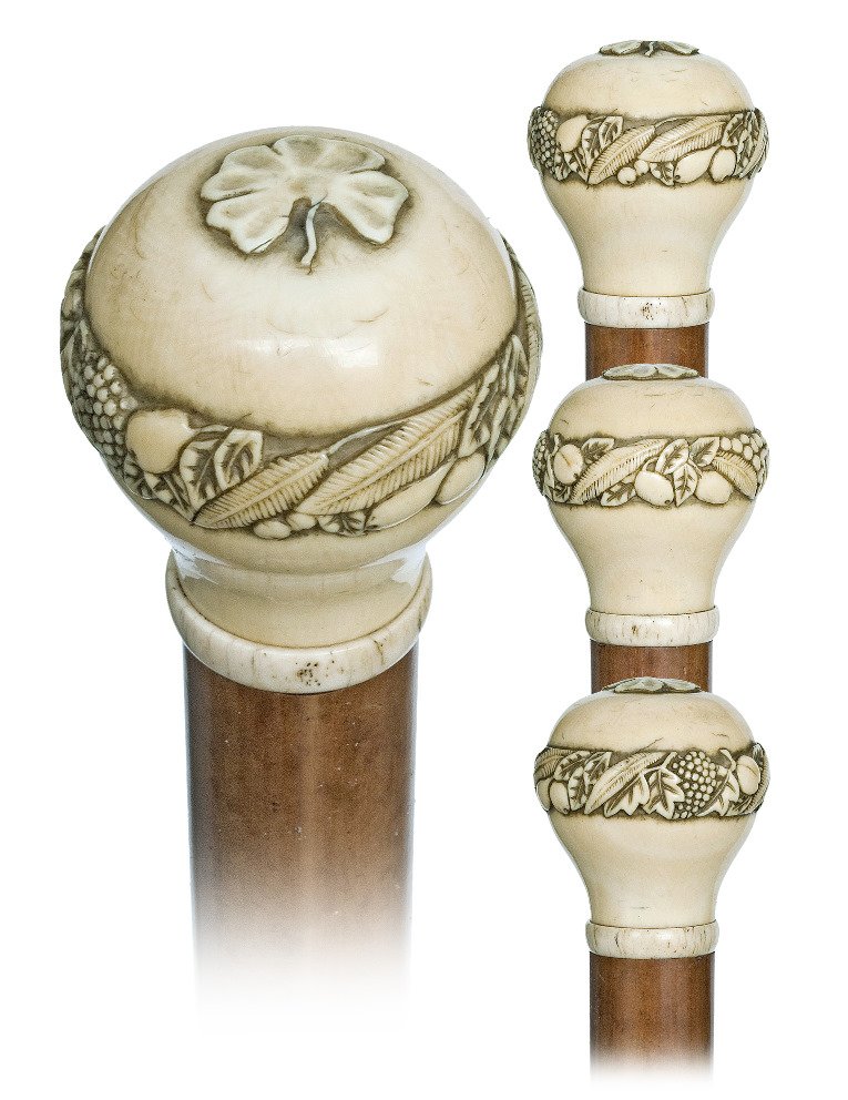 129. Ivory Thanks Giving Mascot Cane-Ca. 1890-Rounded: 129. Ivory Thanks Giving Mascot Cane-Ca. 1890-Rounded ivory knob with an encircling ring of various fruits and vegetables and a four leafed clover, well dressed malacca shaft and an ivory ferrule. Exc